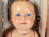 a baby doll sitting in a box on the floor