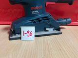 une ponceuse orbitale Bosch posée sur une table, avec une étiquette de prix