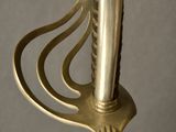 a gold colored sword with a metal handle on a gray background