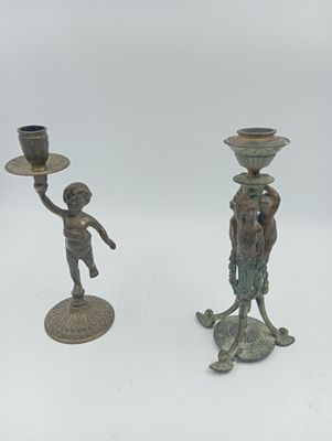 deux bougeoirs en bronze posés sur une table