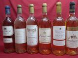 six bottles of wine are lined up in a row on a red background
