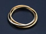 un gros plan d'une bague en or et en argent sur une surface noire