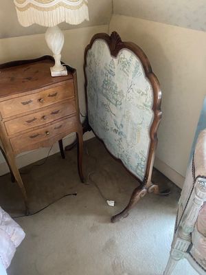 un lit et une commode dans une pièce où une lampe est allumée