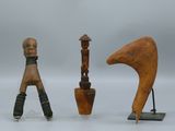 trois sculptures en bois de formes et de tailles différentes posées sur une surface blanche