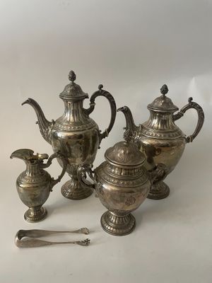 trois théières en argent et deux cuillères en argent posées sur une table