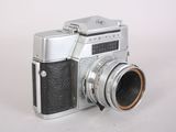 a silver and black camera on a white surface