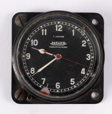 une horloge noire avec une trotteuse rouge sur un fond blanc