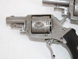 two revolvers on a white table with a black handle