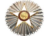 une image représentant une étoile en métal sur laquelle est apposée une médaille d'or