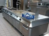 a large kitchen with stainless steel appliances and counters
