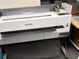 une grande imprimante posée sur un bureau dans une pièce