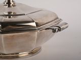 a silver plate with a lid on a white table