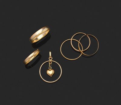 trois bagues en or et un pendentif en forme de cœur sur fond noir