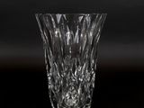 vase en cristal posé sur une surface noire avec un arrière-plan sombre