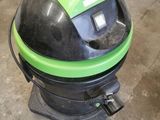 a green and black vacuum cleaner sitting on the floor