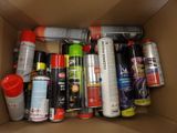 a cardboard box filled with spray paint and other items
