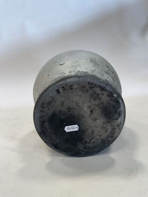 an old metal cup sitting on top of a white table