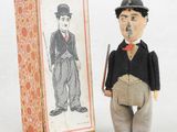 une petite figurine représentant un homme debout à côté d'une boîte