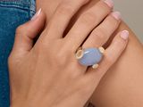 La femme porte une bague sertie d'une pierre bleue.