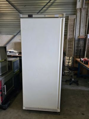 a white refrigerator in a garage next to other appliances