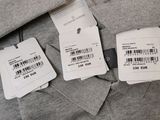 two tags on a gray shirt with a barcode on it