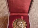 un gros plan sur une médaille posée dans une boîte rouge sur une table