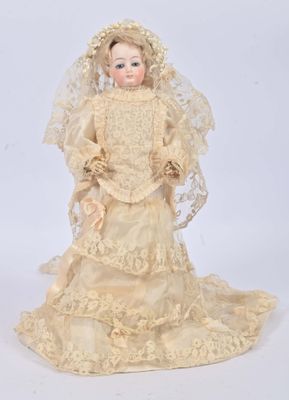 an antique doll of a woman wearing a wedding dress and veil