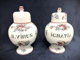 pair of ceramic urns with floral designs on them on a black background