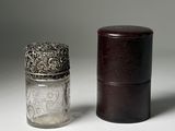 a small glass jar with a silver lid next to a small glass jar with a silver lid