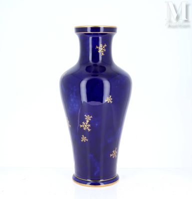 un vase bleu orné d'étoiles dorées, posé sur un fond blanc