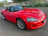 the red sports car is parked in the parking lot