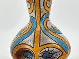un vase avec un motif sur une surface blanche