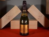 une bouteille de champagne posée sur une table, à côté de caisses en bois