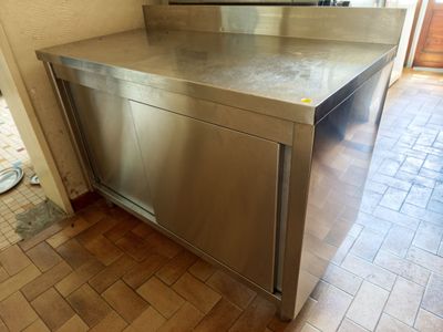 a stainless steel counter with a mirror on it