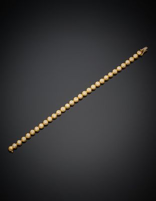 un bracelet en or orné de perles sur fond noir