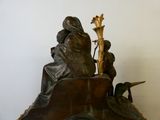 une statue représentant un homme et une femme assis au sommet d'une horloge