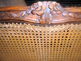 les sculptures sur le dossier d'une chaise en osier dans un salon