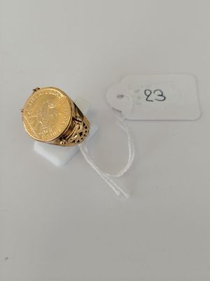 a close up of a ring with a gold coin on it