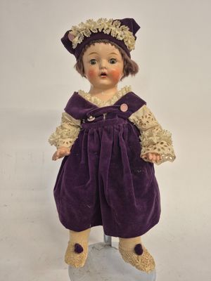 a close up of a small doll on a white surface