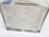 a glass vase with a silver lid on a white surface