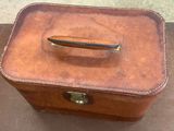 a brown suitcase sitting on a table with a handle