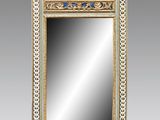 un miroir au cadre doré ouvragé, orné d'une bordure bleue et blanche
