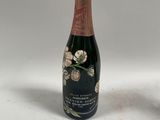 une bouteille de champagne posée à côté d'un verre de vin