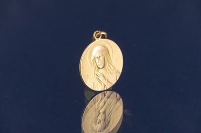 gros plan d'une médaille d'or sur une surface noire