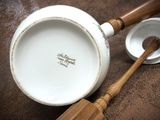 a white bowl and a wooden spoon on a table