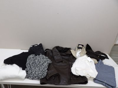 une table blanche sur laquelle sont posés des vêtements et une paire de chaussures