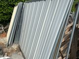 a metal fence that is leaning against a building