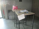 une petite table sur laquelle est posé un panneau, dans une pièce