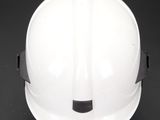 white hard hat on a black table with a black background