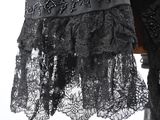 a black dress with lace on it on a mannequin stand